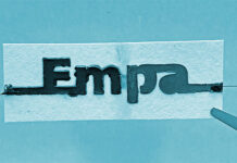 Die Papierbatterie besteht aus zwei in Reihe geschalteten elektrochemischen Zellen an den beiden Enden des Papierstreifens, die durch eine Wasserbarriere (zwischen den Buchstaben «m» und «p») getrennt sind. Foto: Empa