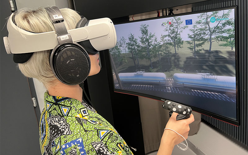 Güterzug-Vorbeifahrt spielerisch erleben: Der Monitor zeigt, was die Nutzerin in virtueller Realität dreidimensional sieht – mit dem realistischen Bahnlärm exakt in ihrer Position. Foto: Empa