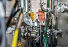 Yaroslav Romanyuk hinter der grossformatigen Anlage «CT200» mit drei Kammern für die Herstellung von Dünnschichten. Sie ist das Herzstück des «Coating Competence Center» der Empa, das 2016 in Betrieb ging. Foto: Empa