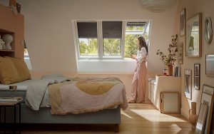 Rollläden schirmen mit ihrem Aluminiumgehäuse das Dachfenster komplett vor der Sonnenstrahlung ab. Damit halten sie nicht nur die Hitze am effektivsten ab, sondern verdunkeln den Raum vollständig und schützen zudem vor Lärm. Foto: Velux