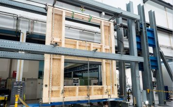 Eine zweigeschossige Hauswand mit Fensteröffnungen wird kontrolliert unter Druck gesetzt. Die Forschenden führten eine Reihe solcher Versuche an der Empa durch. Foto: Empa