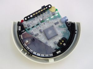 Auf der durch eine thermisch aufgeschmolzene Wachsschicht vor Korrosionseinflüssen geschützte Leiterplatte ist der im Melder verbaute Rechner oder Mikroprozessor sichtbar. Die gut nachvollziehbare interne Bezeichnung für die zusammen mit 3M entwickelte Korrosionsschutzmethode hiess Raclette. Foto: Siemens AG