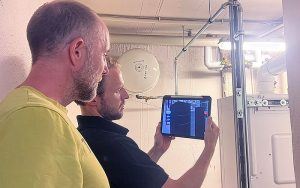 Die App «Heat Pump PlanAR» wird im Heizungskeller erprobt. Die Komponenten des Heizungsschemas werden dabei in Augmented Reality vor den Hintergrund projiziert. Foto: Fraunhofer ISE/mit KI-Unterstützung